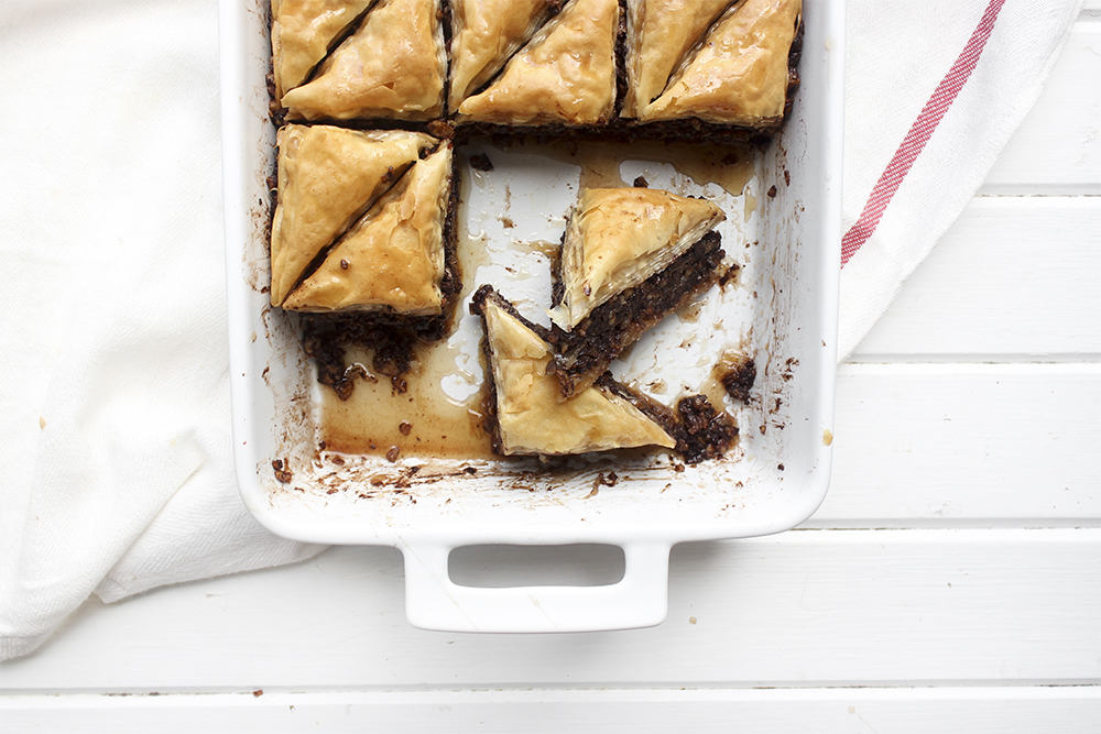 Chocolate Hazelnut Baklava - Flaky, crispy phyllo dough layered with hazelnuts and bittersweet chocolate chocolate, topped with a honey-cocoa nib syrup that provides a twist on the traditional walnut/almond greek baklava dish #baklava #dessert #dessertrecipe #sweetdessert #phyllodough #phyllo #hazelnut #chocolate 