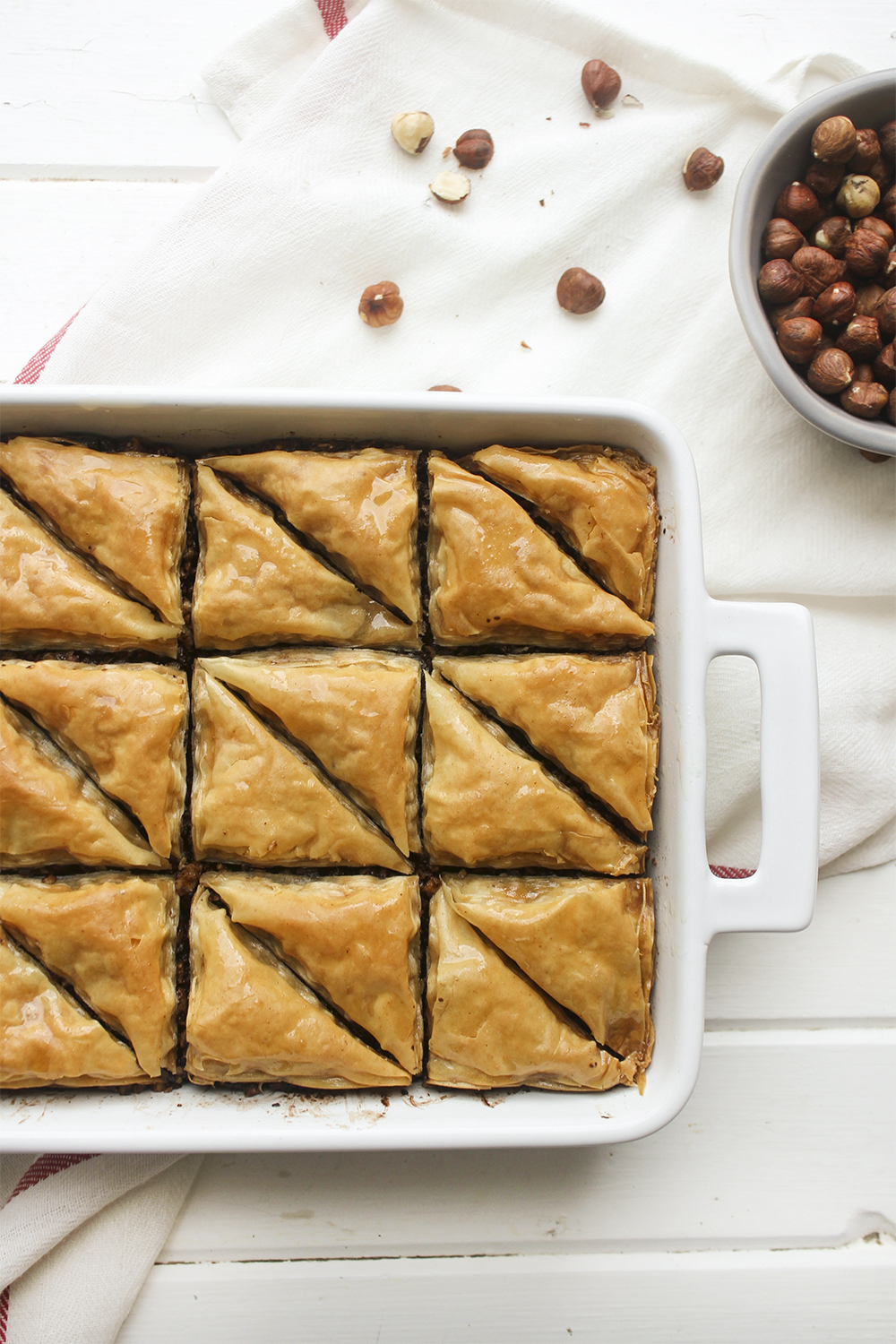 Chocolate Hazelnut Baklava - Flaky, crispy phyllo dough layered with hazelnuts and bittersweet chocolate chocolate, topped with a honey-cocoa nib syrup that provides a twist on the traditional walnut/almond greek baklava dish #baklava #dessert #dessertrecipe #sweetdessert #phyllodough #phyllo #hazelnut #chocolate 