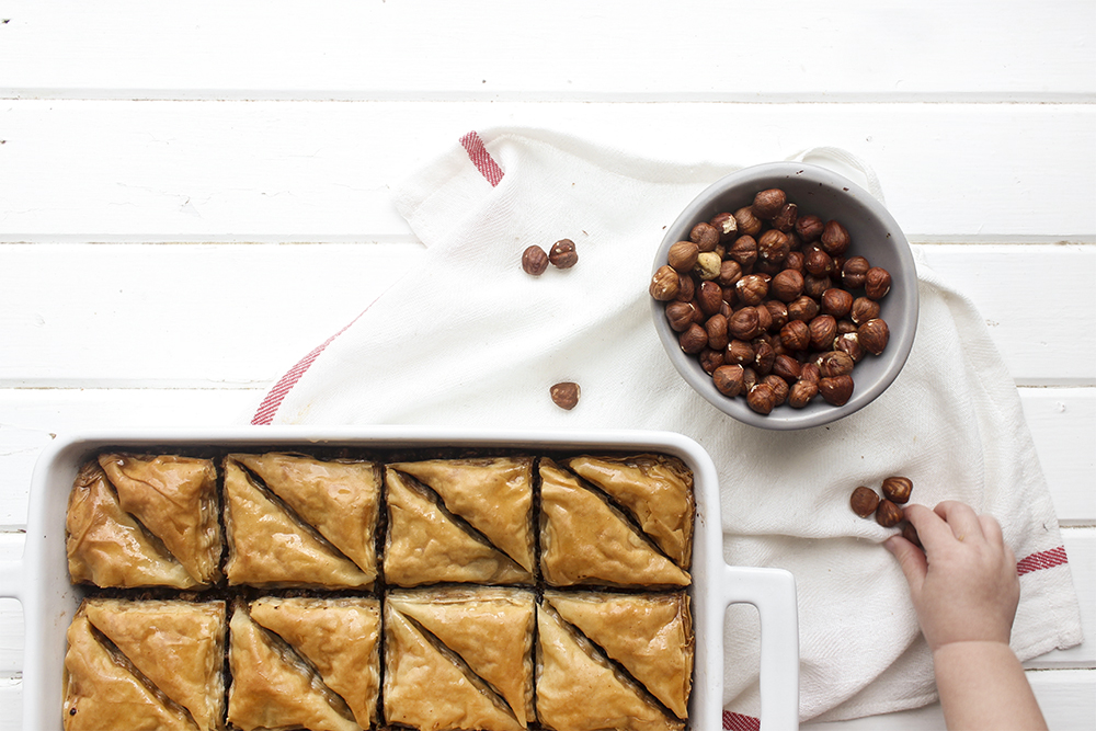 Chocolate Hazelnut Baklava - Flaky, crispy phyllo dough layered with hazelnuts and bittersweet chocolate chocolate, topped with a honey-cocoa nib syrup that provides a twist on the traditional walnut/almond greek baklava dish #baklava #dessert #dessertrecipe #sweetdessert #phyllodough #phyllo #hazelnut #chocolate 