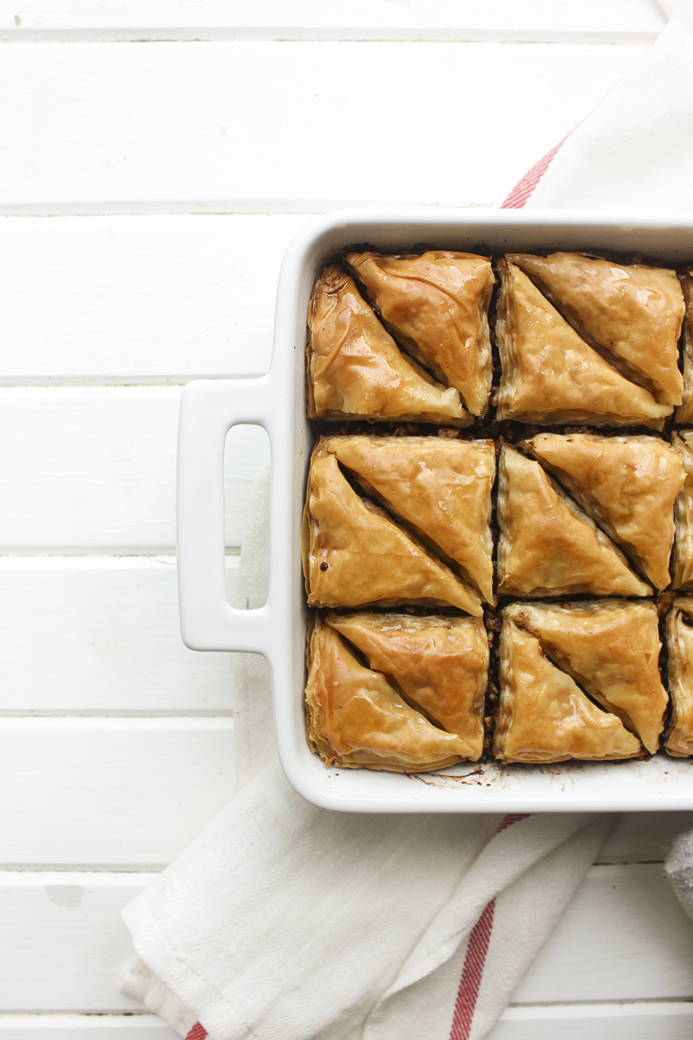 Chocolate Hazelnut Baklava - Flaky, crispy phyllo dough layered with hazelnuts and bittersweet chocolate chocolate, topped with a honey-cocoa nib syrup that provides a twist on the traditional walnut/almond greek baklava dish #baklava #dessert #dessertrecipe #sweetdessert #phyllodough #phyllo #hazelnut #chocolate 